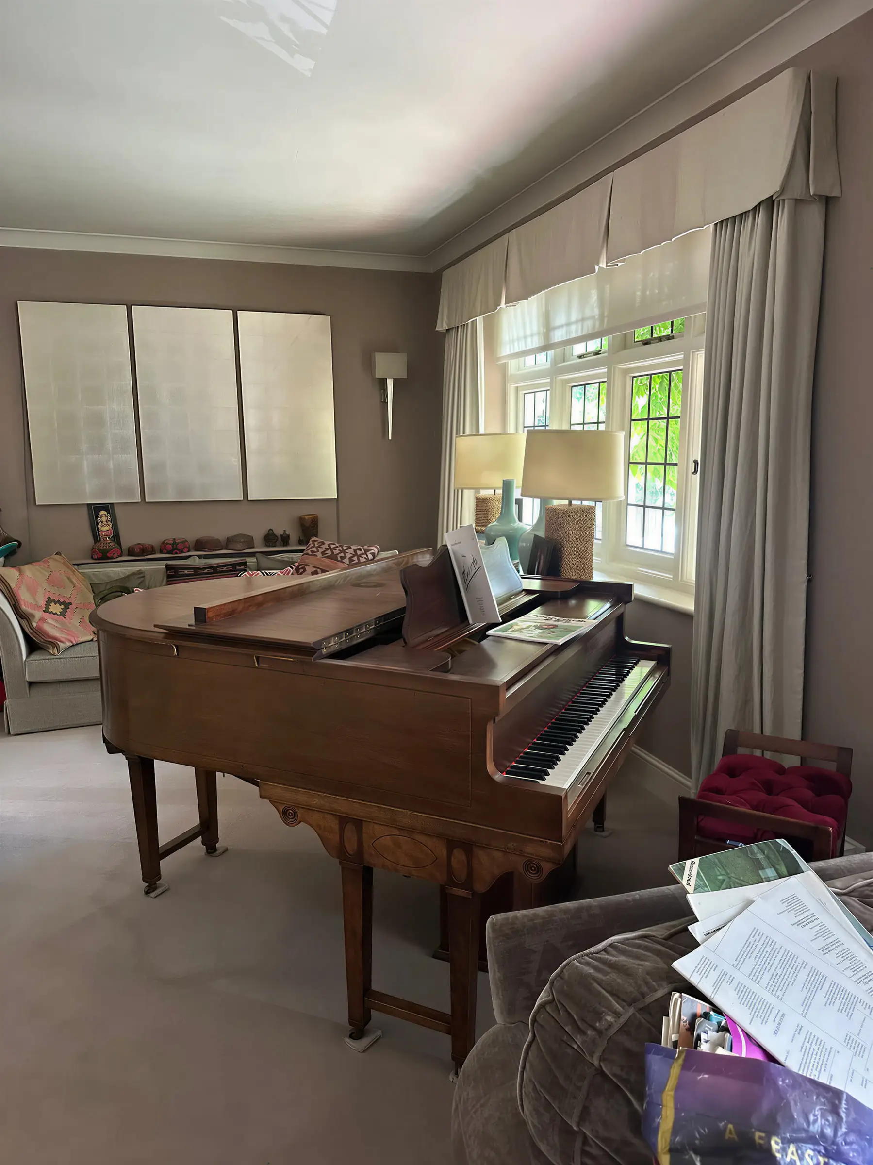 A wooden baby grand piano standing in a living room
