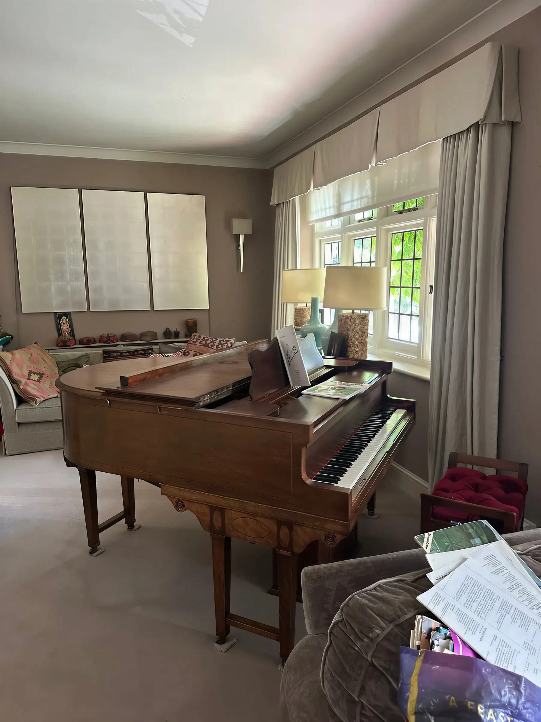 A wooden baby grand piano standing in a living room