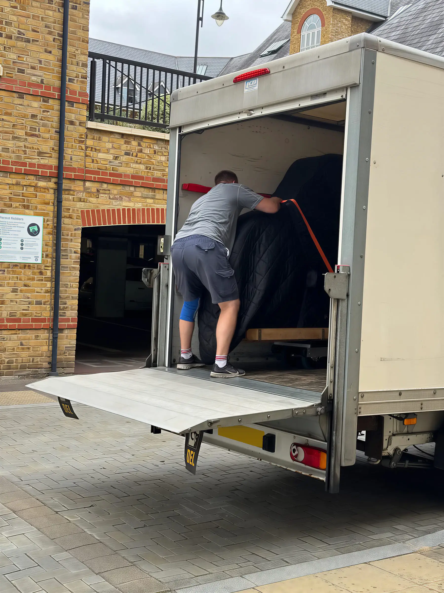 A mover inside the VVM van steadying the wrapped piano before the drive