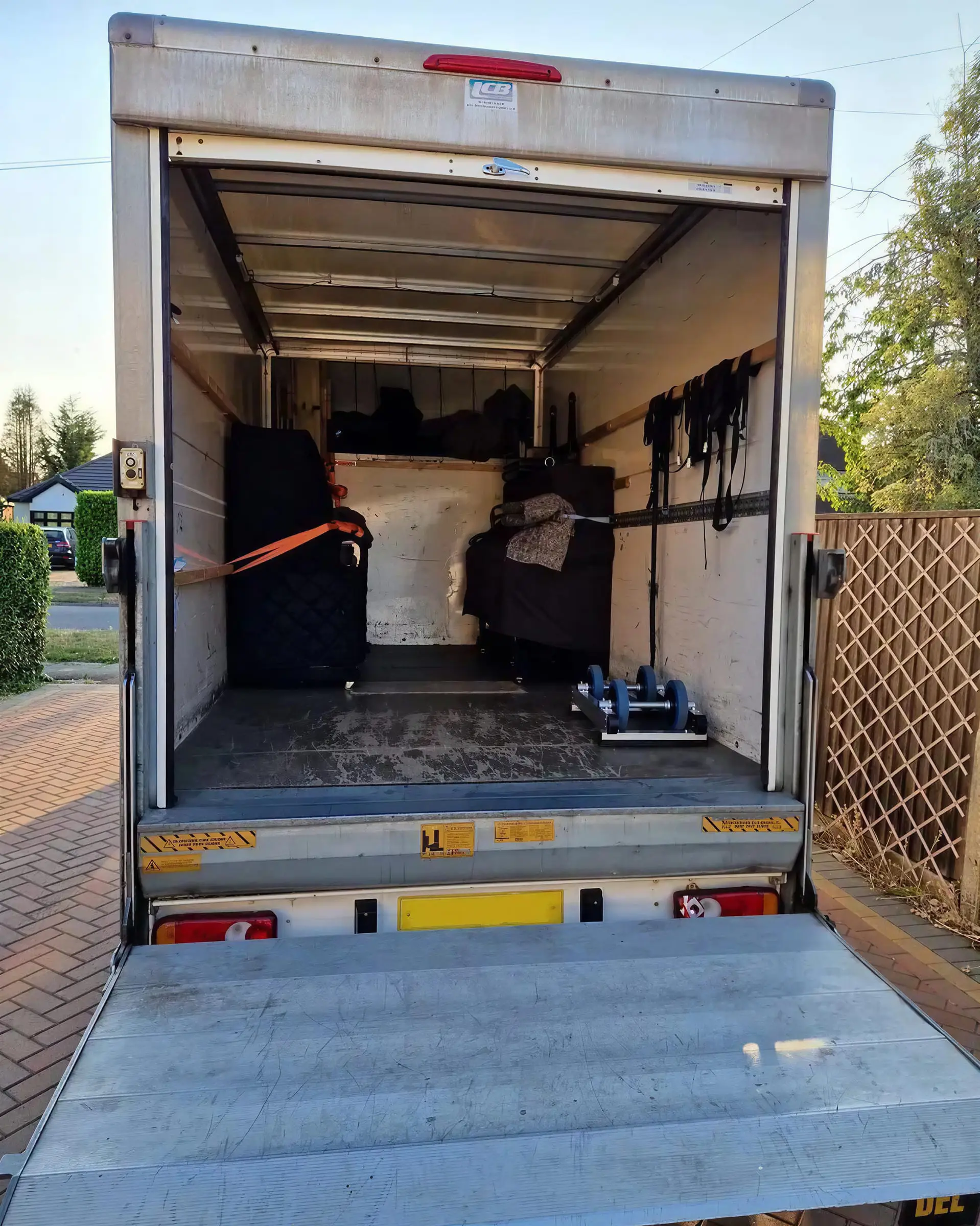 Two wrapped pianos strapped upright inside the VVM van
